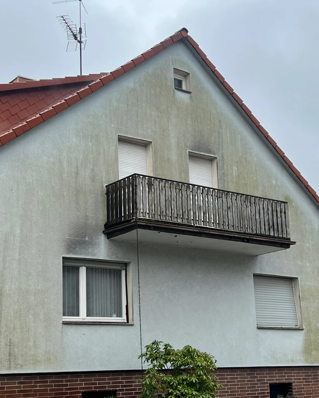Dunkle Ablaufspuren und Algen an einem Giebel
