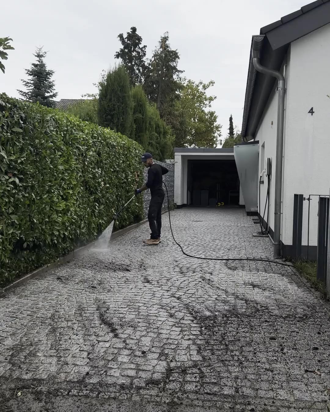 FDS-Team reinigt eine gepflasterte Einfahrt mit Heißwasser